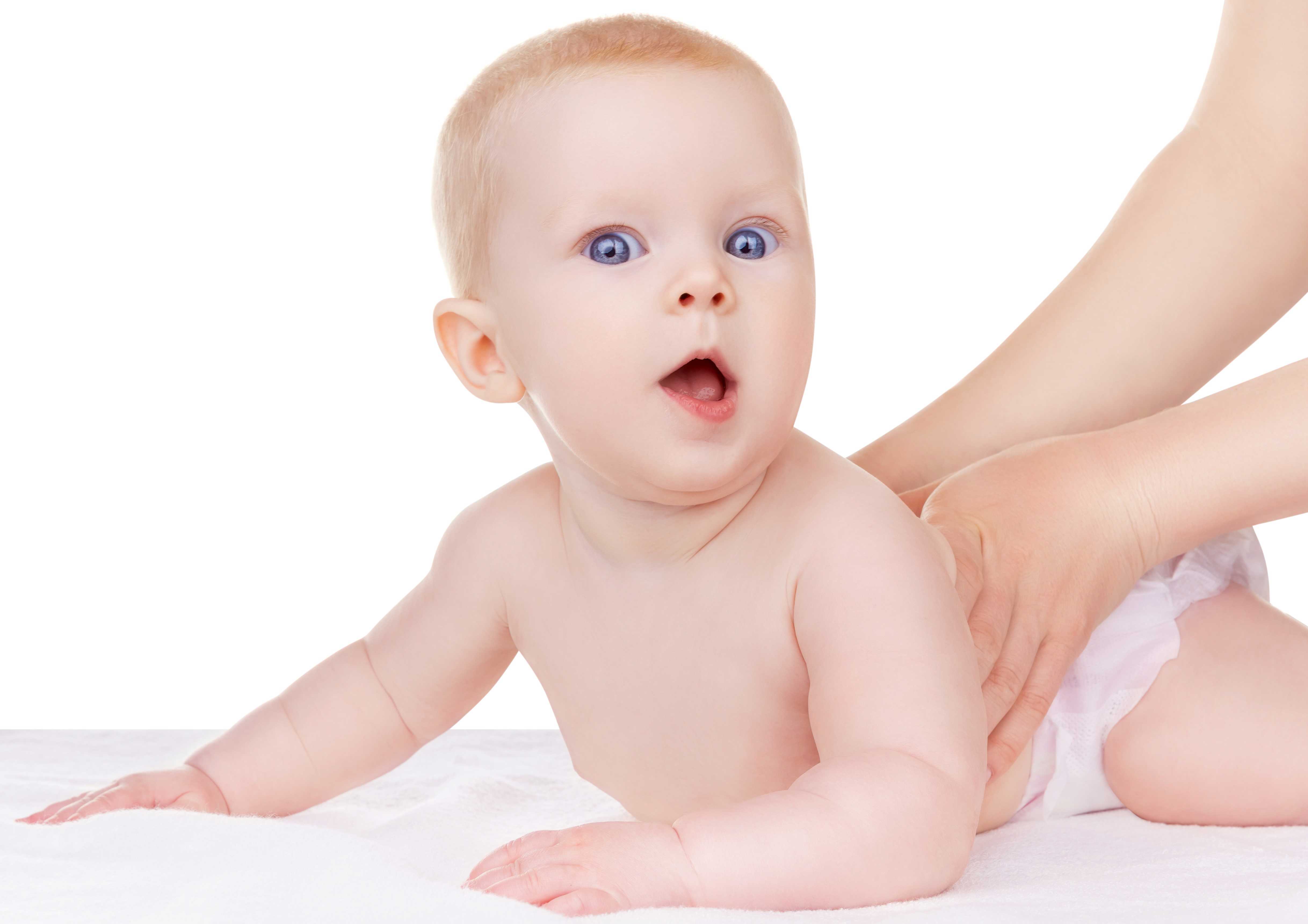 Baby der ligger på maven og løfter hovedet.