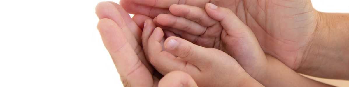 Fremstrakte hænder der holder et par barnehænder