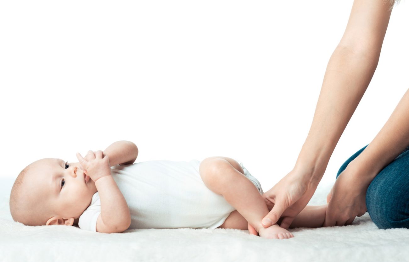 En baby får hjælp til at lære at trille