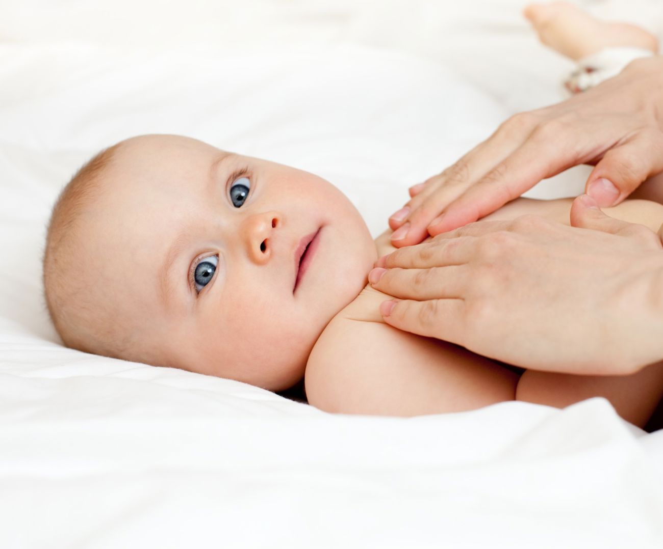 En forælder giver sin baby blid massage
